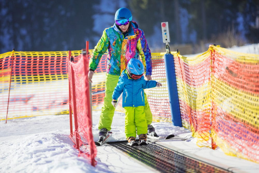 Bambino sulla neve usa tappeto di risalita della Skiarea di Livigno